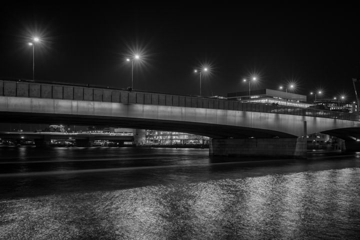 Black and white photograph of London Bridge at night.