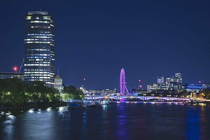 Millbank Tower in blue sky at Night with Pink London eye and Pink lambeth bridge