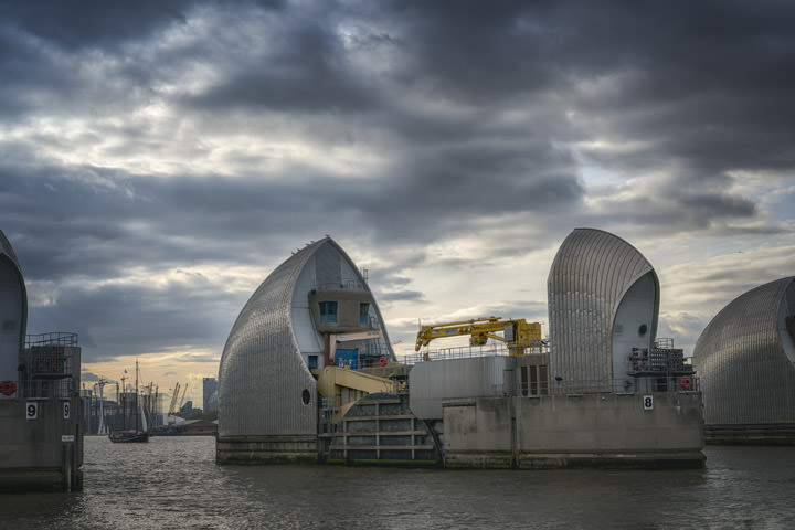 Thames Barrier at dusk beneath stormy skies