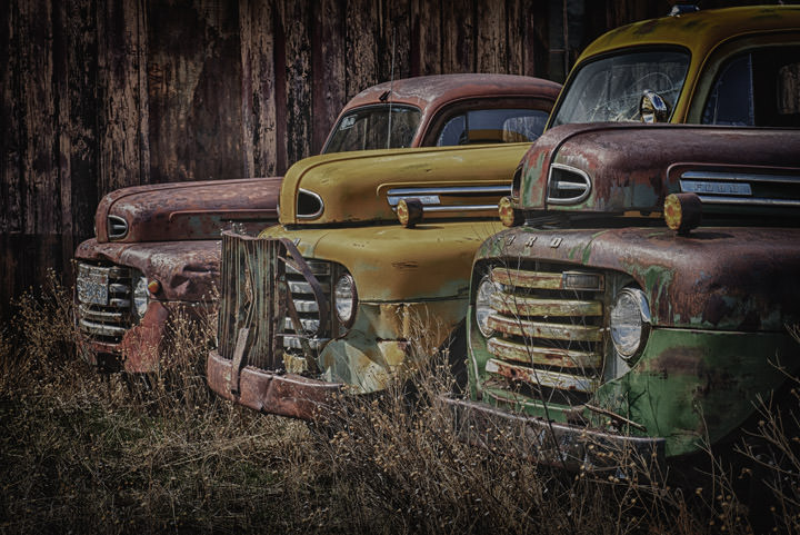 Three old farm trucks in colour